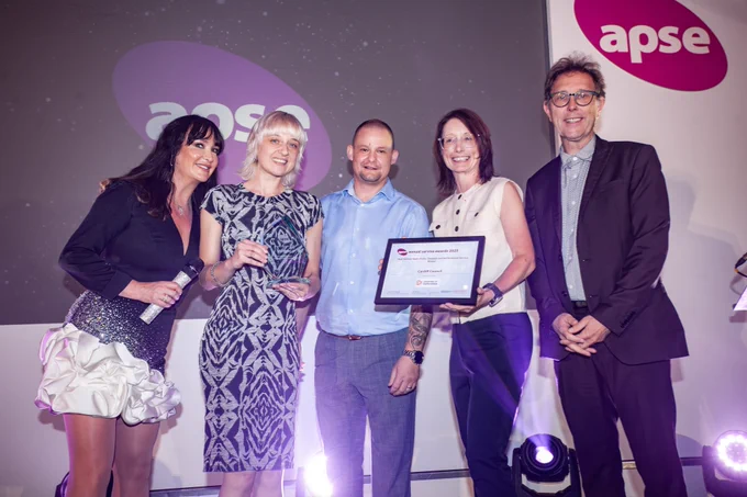 Group of 5 people with an award