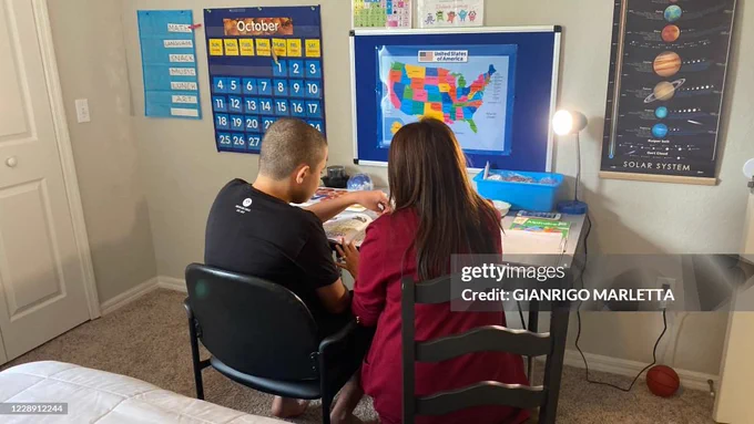 A 50-year-old mother supporting her 14-year-old son with autism in homeschooling, Orlando, Florida, US, October 1, 2020. (C) 2020 Gianrigo Marletta/AFP via Getty Images 
