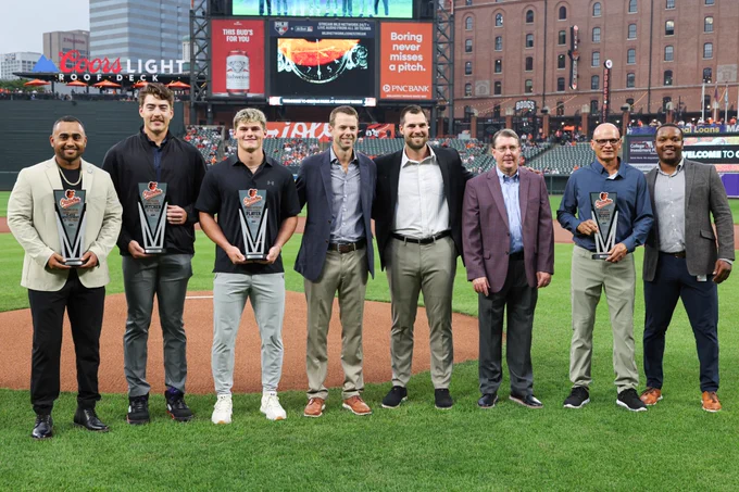 The Orioles 2025 Minor League Award winners pose for a photo on the field.