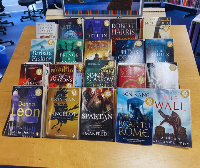 A photo of a fiction book display in Godalming Library showing rows of Ancient History books with yellow stickers in the corner that say ‘DISCOVER’ 