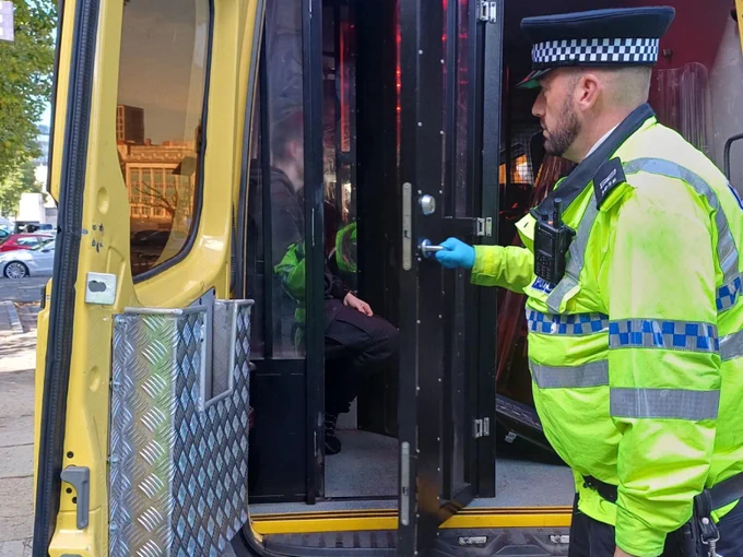 Project Servator officer securing a detained male inside a police carrier's cell