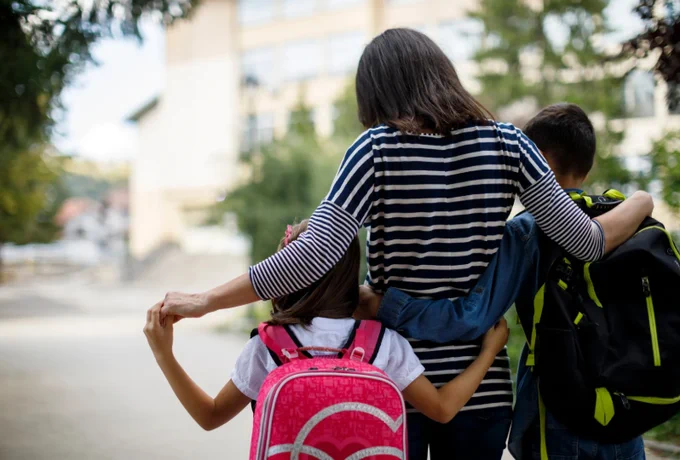 Image of a mum walking her children to school.