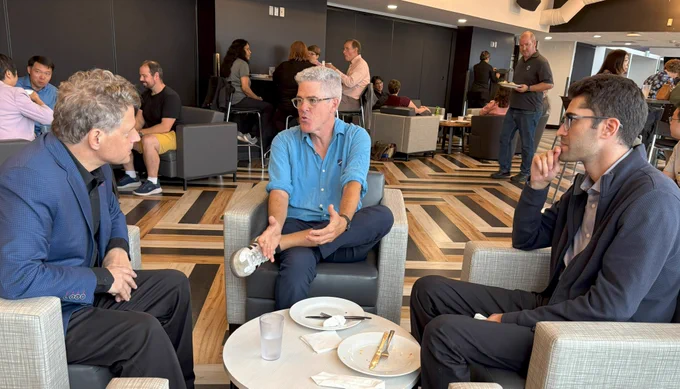 Two WLUFA Members and WLUFA's new Labour Relations Officer, Martin Devitt having a conversation seated around a small table.