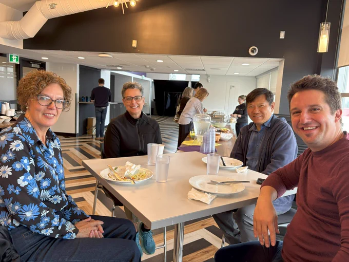 Four WLUFA Members at a table, smiling for the camera.