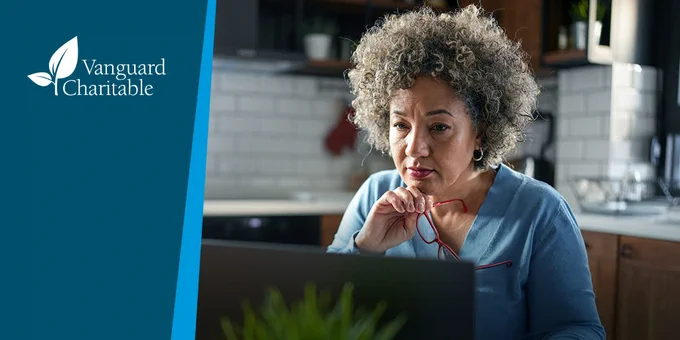 Older African American woman sitting in front of a laptop looking concerned. 