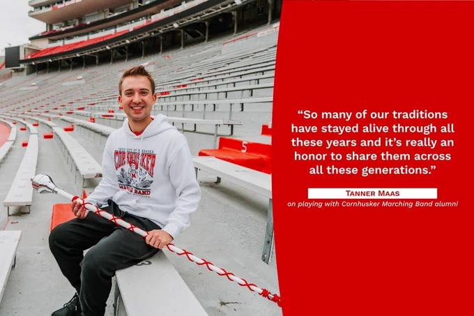 Tanner sitting on the bleachers at Memorial Stadium, holding a drum stick. The graphic reads, "So many of our traditions have stayed alive through all these years and it's really an honor to share them across generations. Tanner Maas on playing with Cornhusker Marching Band alumni"
