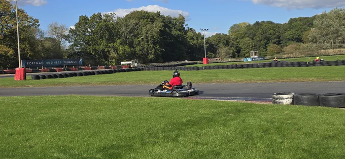 A person driving a go-kart on an outdoor track.