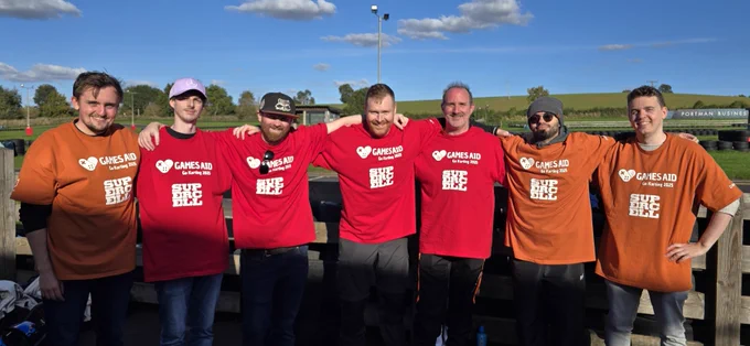 The Red Kite and Sumo team racers standing shoulder to shoulder with arms around each other, smiling for the camera.