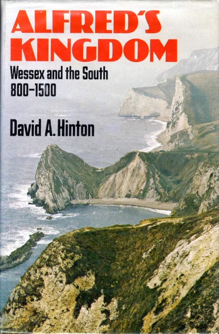 A coastal view of craggy cliffs and the sea, with the title details in the top left corner