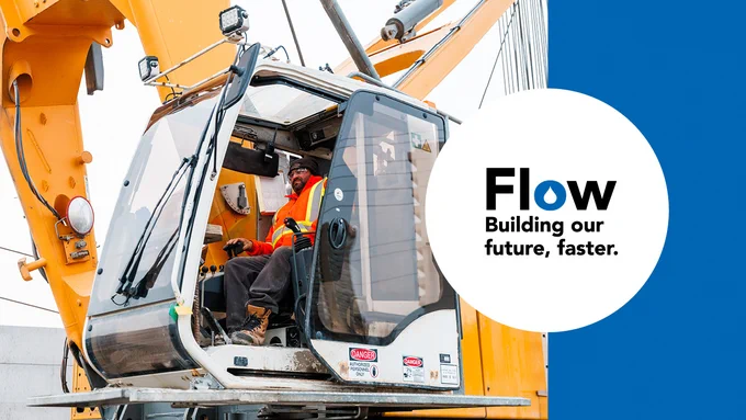 A construction worker is operating a large machine. The text next to the image in a white circle reads: "Flow, building our future, faster."