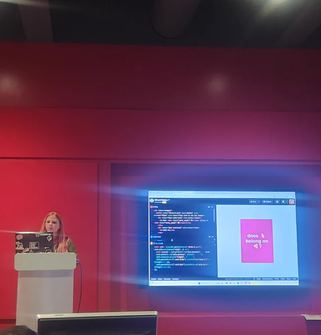 Presenter at a tech conference with a code pen projection 