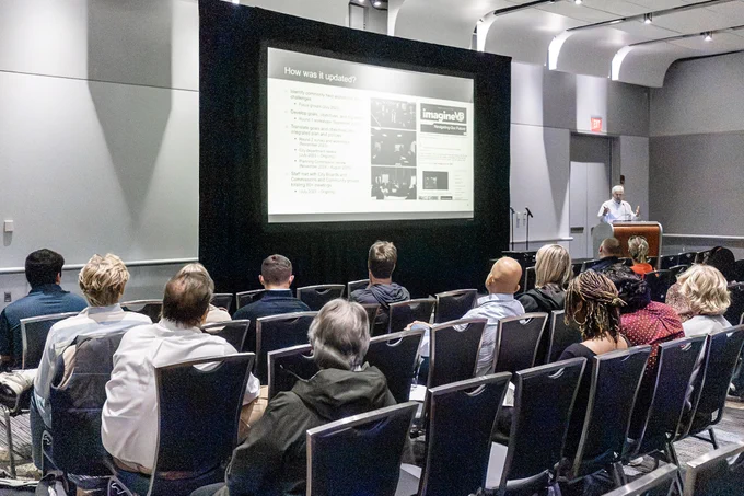 Audiences listening to a speaker at a meeting indoors