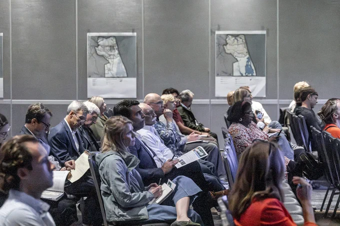 Audiences listening to a speaker at a meeting indoors