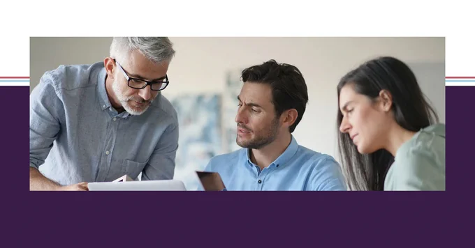Three colleagues collaborate with laptops