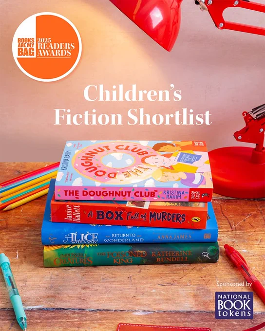 Promotional image for the "Books Are My Bag Readers Awards 2025," showcasing a stack of colourful books nominated for the Children's Fiction Shortlist, with a red lamp illuminating from above, sponsored by National Book Tokens.