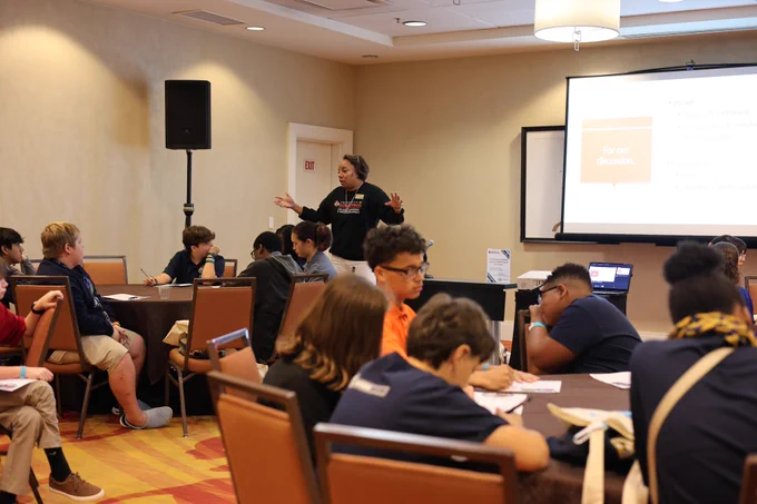 An adult presents to a room of students.
