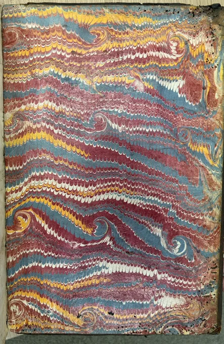 Photo of marbled paper in vibrant blue, red and orange, with some white.  It is a little faded at the edges and the corners in particular have a large number of insect holes.