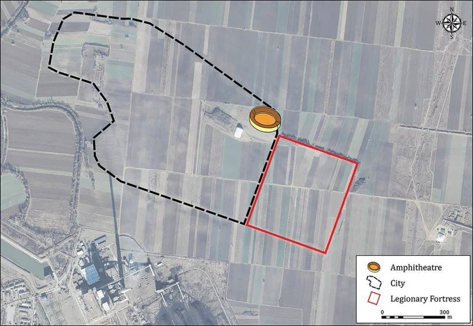 Aerial photograph of modern farmland, divided into different-coloured, rectilinear fields. Overlaid are diagrams indicating the boundaries of the city and legionary fortress, as well as an illustration of a circular building representing the amphitheatre in its location.