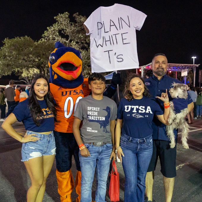 A family five UTSA fans, including Rowdy the mascot, holding a "Plain White T's" sign at last year's BestFest.