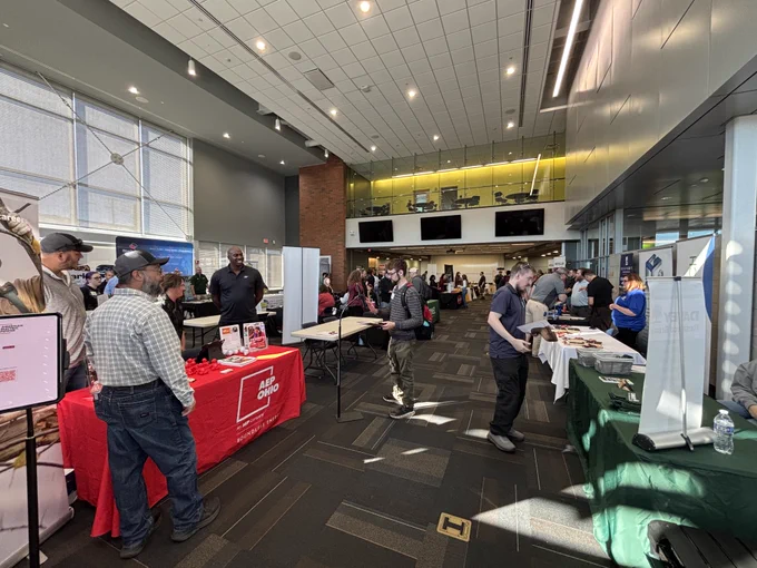 A large exhibition hall for a career fair with various booths and visitors engaging, featuring prominent displays like AEP.