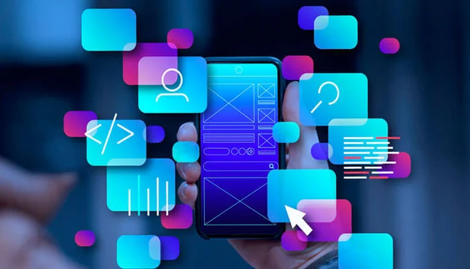 Hand holding a smartphone with wireframe UI and coding icons, representing a modern Web App Development Company.