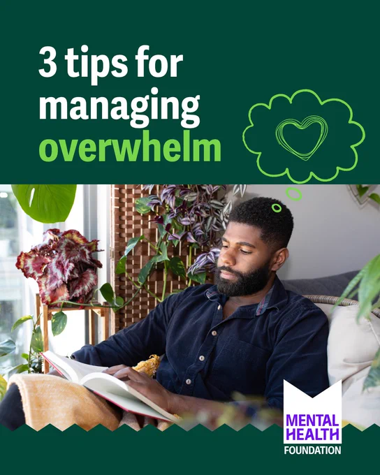 A man with a beard is sitting on a couch, surrounded by various green and red-leafed plants, reading a book. He's wrapped in a light brown blanket. The background features a wooden lattice. Above him is text that reads, "3 tips for managing overwhelm," with a sketched green cloud and heart. The bottom corner has the "Mental Health Foundation" logo.
