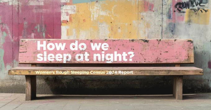 Worn wooden bench with pink backrest displaying the question 'How do we sleep at night?' against a colourful, graffiti-covered wall.