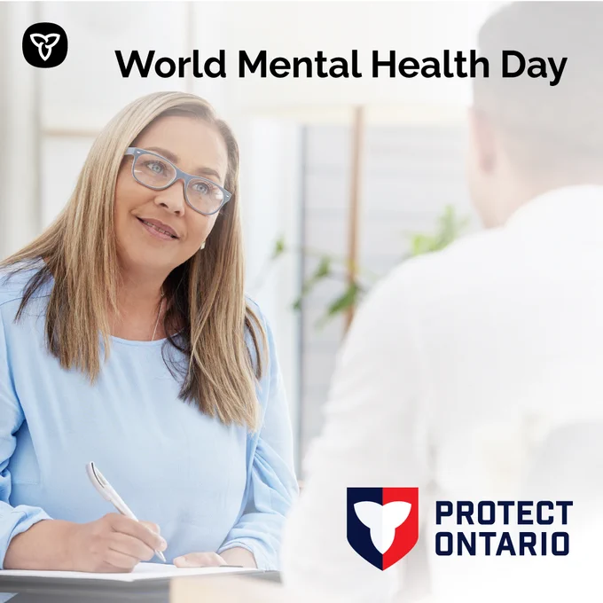 One person listening and taking notes as the other talks. Image Text: World Mental Health Day.
