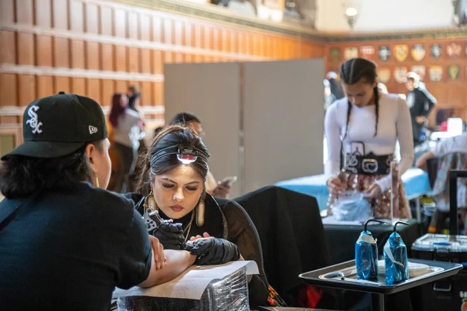 Indigenous Tattoo Artist giving a person a tattoo on their arm 