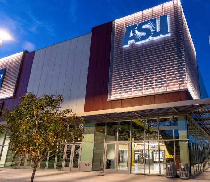 Image of the ASU Mullett Arena at night with the ASU logo glowing from the lights. 