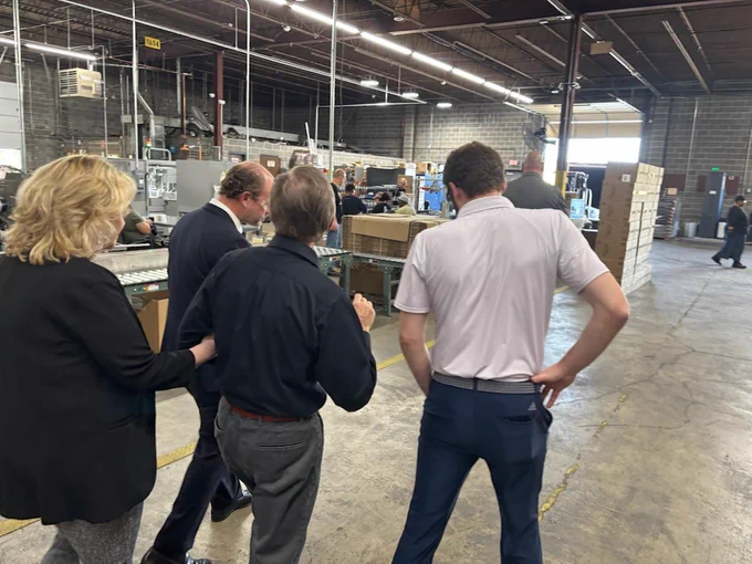 Acting Chairman Peter Feldman and Lighthouse for the Blind staff walk the production floor during a tour of the St. Louis facility, observing aerosol manufacturing operations and packaging lines.