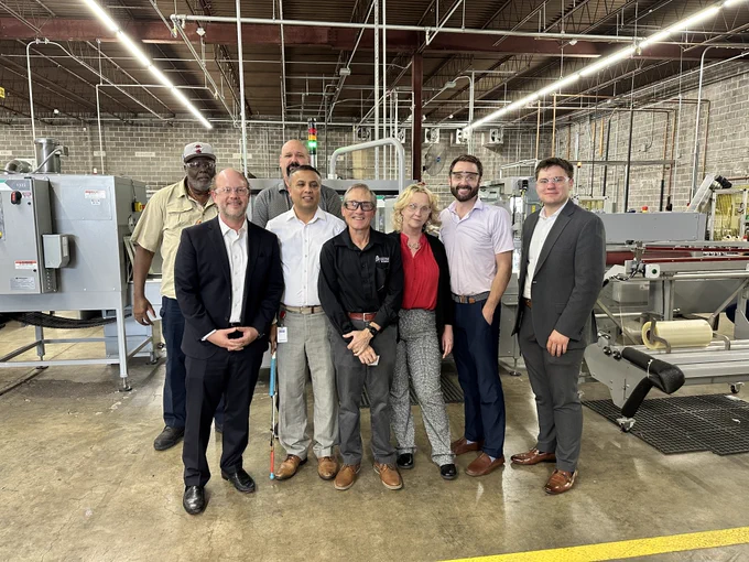 Acting Chairman Peter Feldman with Lighthouse for the Blind team members and guests inside the St. Louis manufacturing facility, standing in front of production equipment that supports hundreds of manufacturing jobs for blind and visually impaired Americans.