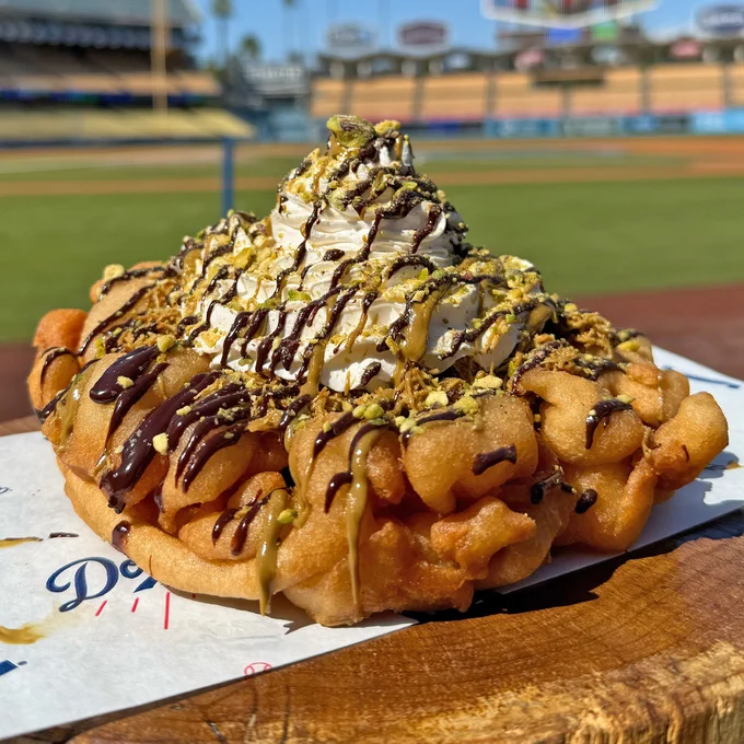 A funnel cake with pistachio cream, chocolate, toasted kataifi, whipped cream, chocolate drizzle and pistachios