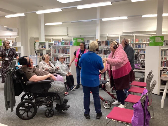 A picture of a group of people dancing while wearing headphones