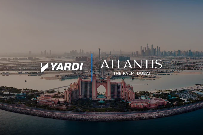 Aerial view of Atlantis The Palm, Dubai, with the logos of Yardi and Atlantis visible in the sky above the resort.