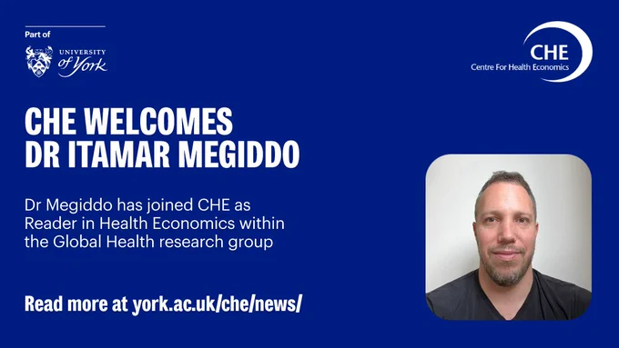 
A promotional graphic from the University of York's Centre for Health Economics (CHE) on a dark blue background. The text reads: "CHE WELCOMES DR ITAMAR MEGIDDO," and below that: "Dr Megiddo has joined CHE as Reader in Health Economics within the Global Health research group." There is a call to action at the bottom: "Read more at york.ac.uk/che/news/". On the right is a close-up photo of Dr. Itamar Megiddo, a man with a beard and short hair, looking directly at the camera.