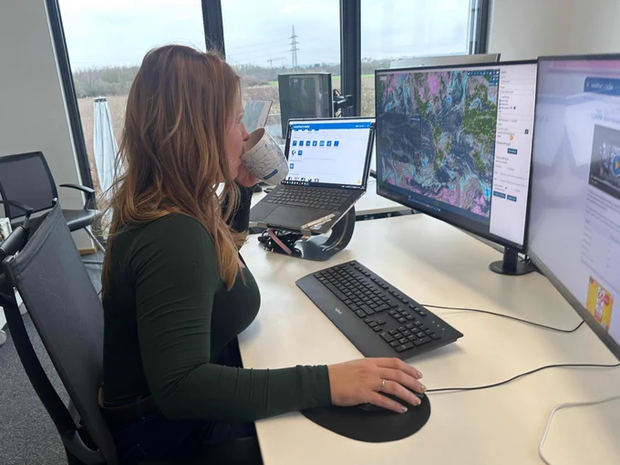 AMS Certified Digital Meteorologist Irene Sans looking at the weather forecast while drinking from a cup.