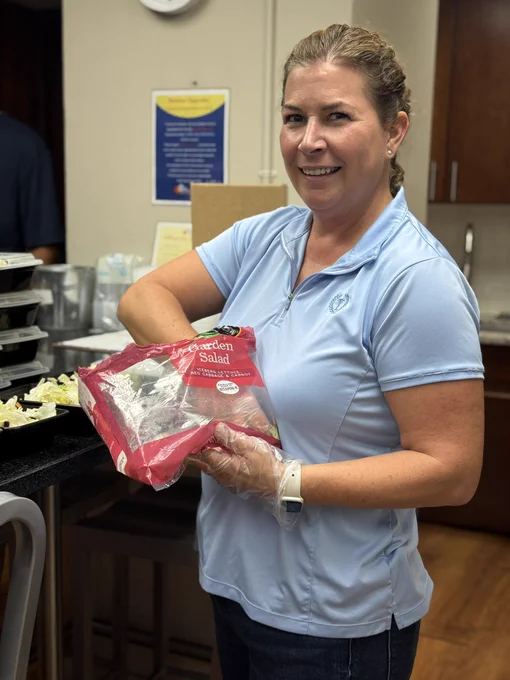 A smiling volunteer makes a meal in the main kitchen of The Doorways