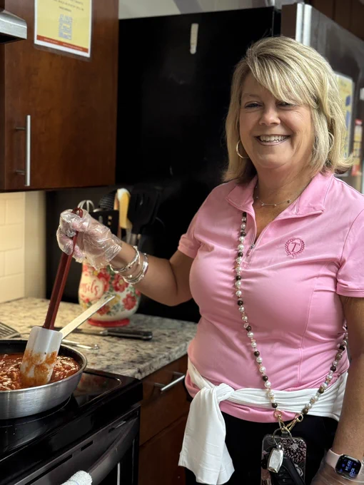 A smiling volunteer makes a meal in the main kitchen of The Doorways