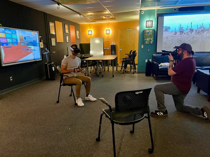 person playing VR while being photographed