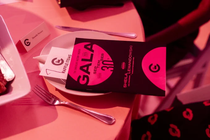 A plate setting with a flyer for a gala at the Chocolate Factory Theater on September 30.