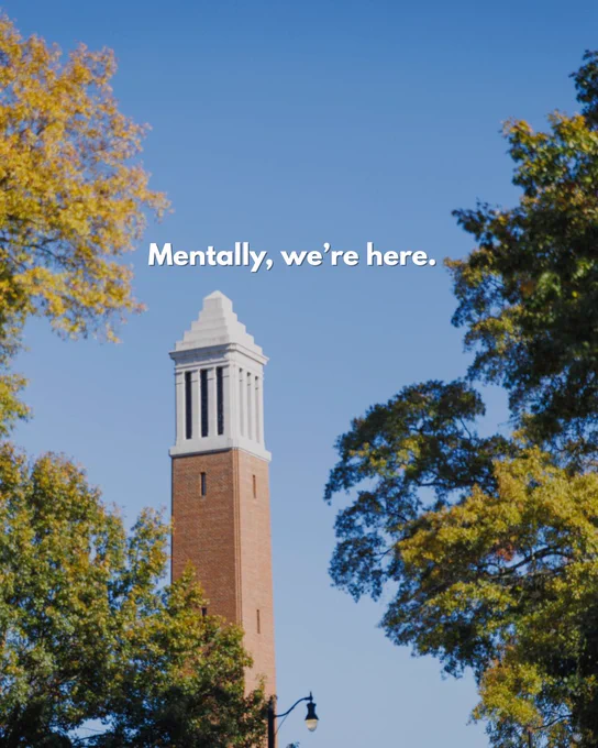 Image of Denny Chimes tower at the University of Alabama, surrounded by trees with yellow leaves under a clear blue sky. The text overlay reads, 'Mentally, we're here.'