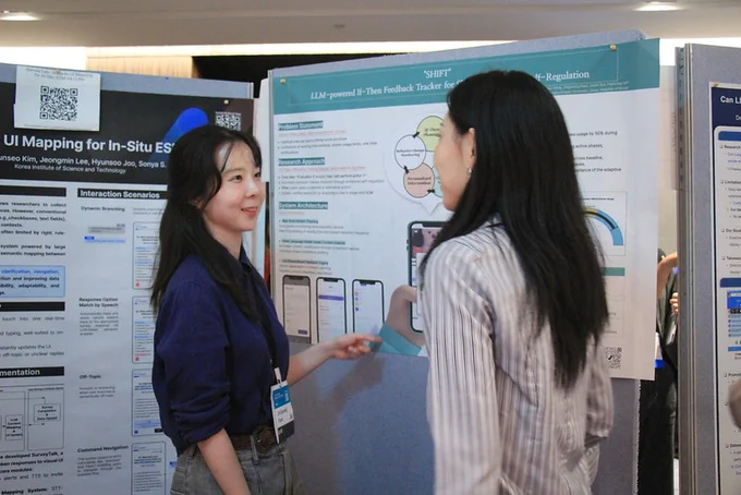 Poster session: two attendees standing in front of the poster.