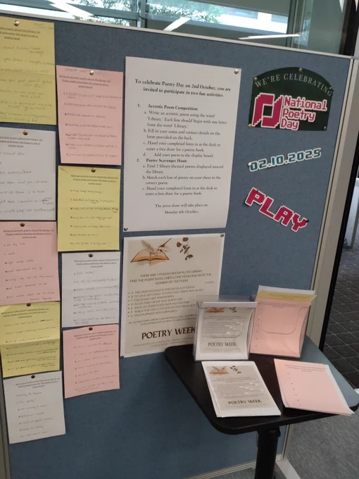 Display of poems pinned on board. Entry forms for acrostic and scavenger hunt. National Poetry Day 2.10.25 on the theme of Play
