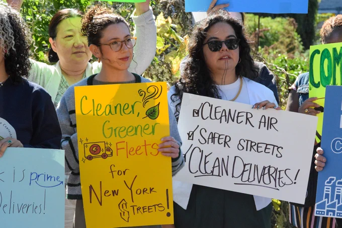Advocates at the rally hold signs reading "Cleaner, Greener, Fleets for New York Streets!" and "Cleaner Air, Safer Streets, Clean Deliveries!"