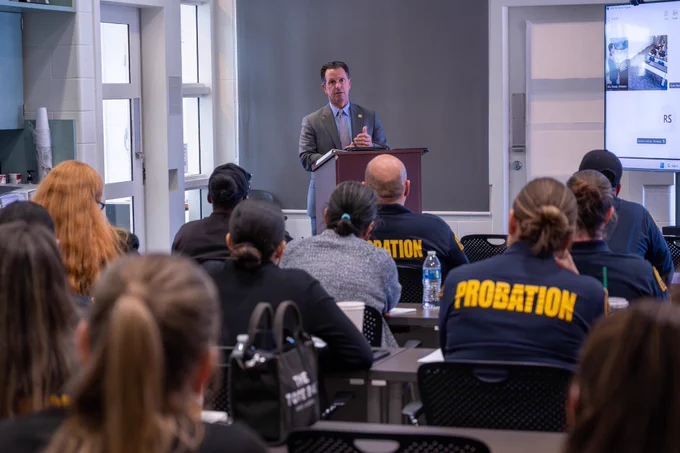 District Attorney Jason Anderson speaking to probation officers in a classroom setting.