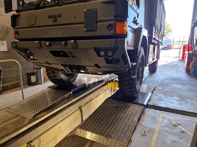 Photo of a military vehicle on a set of surface mounted wheel play detectors from garage equipment supplier Gott Technical Services.