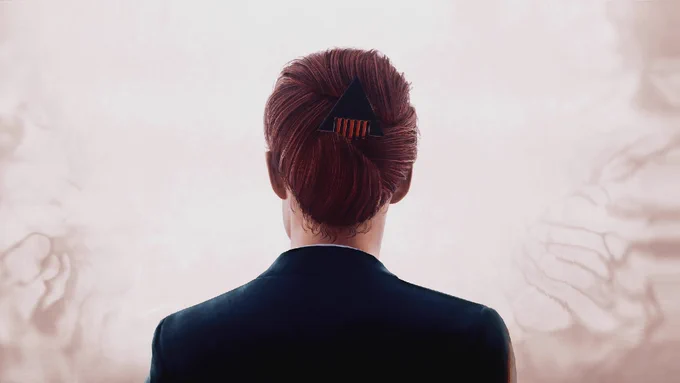 A virtual photograph from Control. Jesse Faden is seen from the back, wearing a smart suit with her hair in a tight bun.