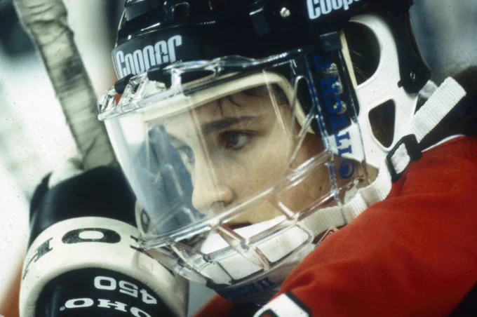 Close-up of a woman staring intently while wearing hockey gear