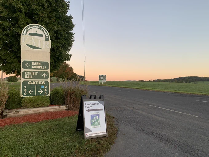 Early morning sunrise along a country road. Sign that says Landowner Event. 